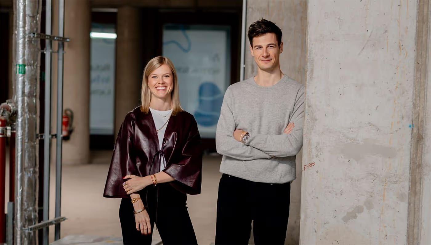 Dr. Eike Julia Muhr und François Casanova stehen nebeneinander in einem Raum mit Sichtbeton.