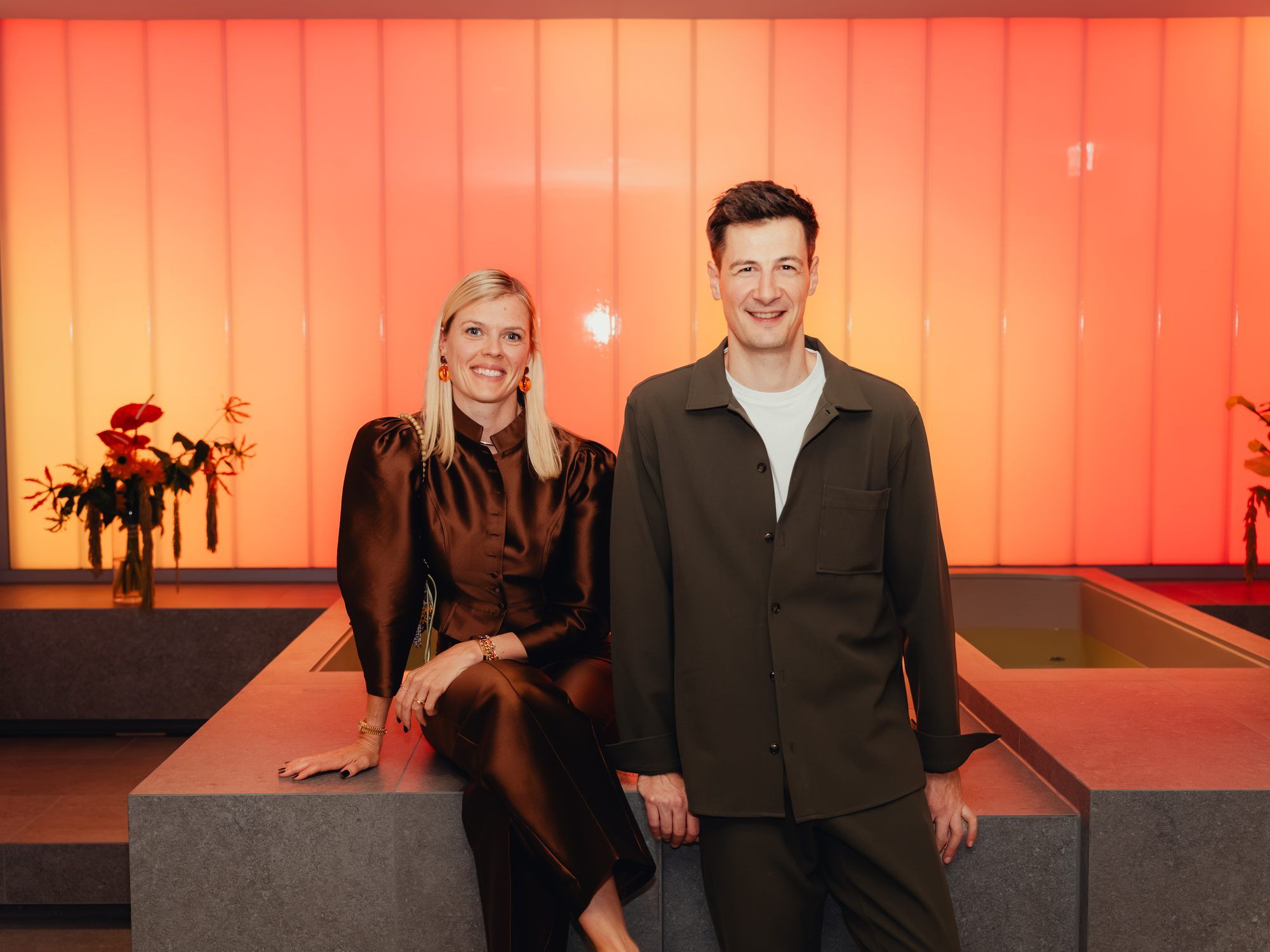 Dr. Eike Muhr and François Casanova in front of a backlit orange wall