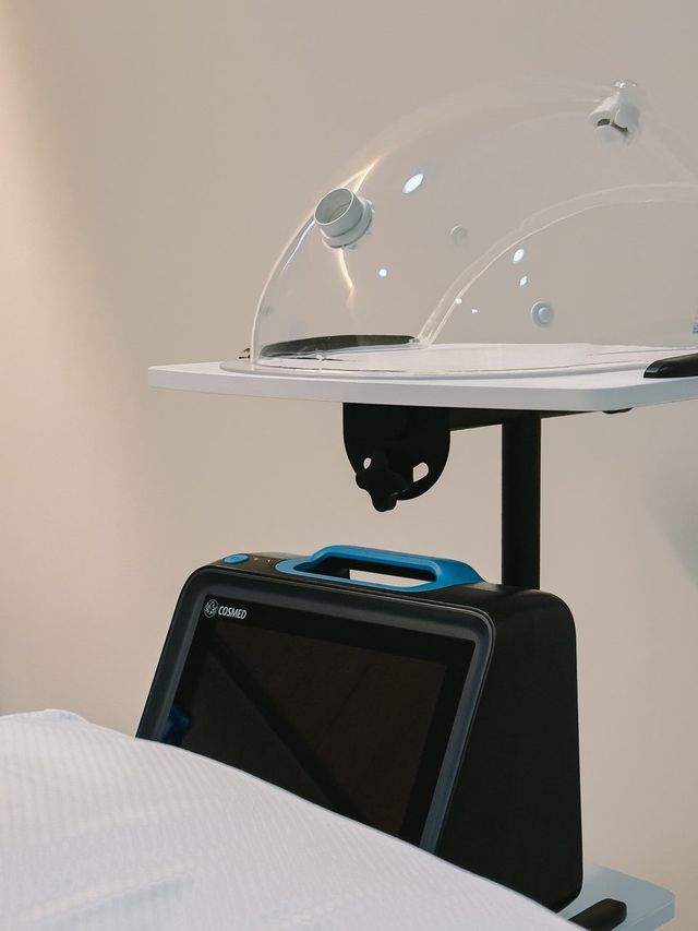 Clear breathing hood above the bed, below it the measuring device