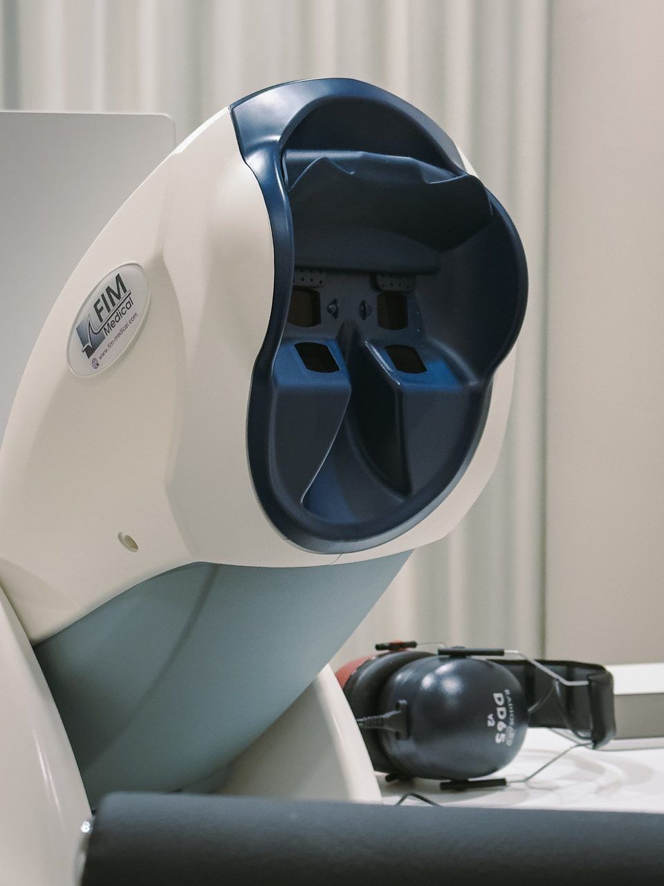 Vision screener with its eyepiece, next to it the headphones for the hearing test